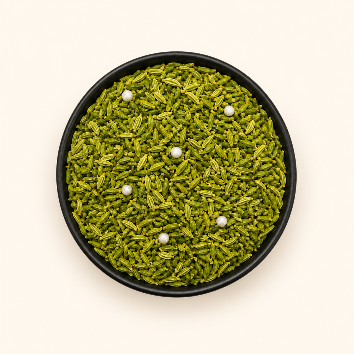 Green Saunf in a bowl on an off-white background