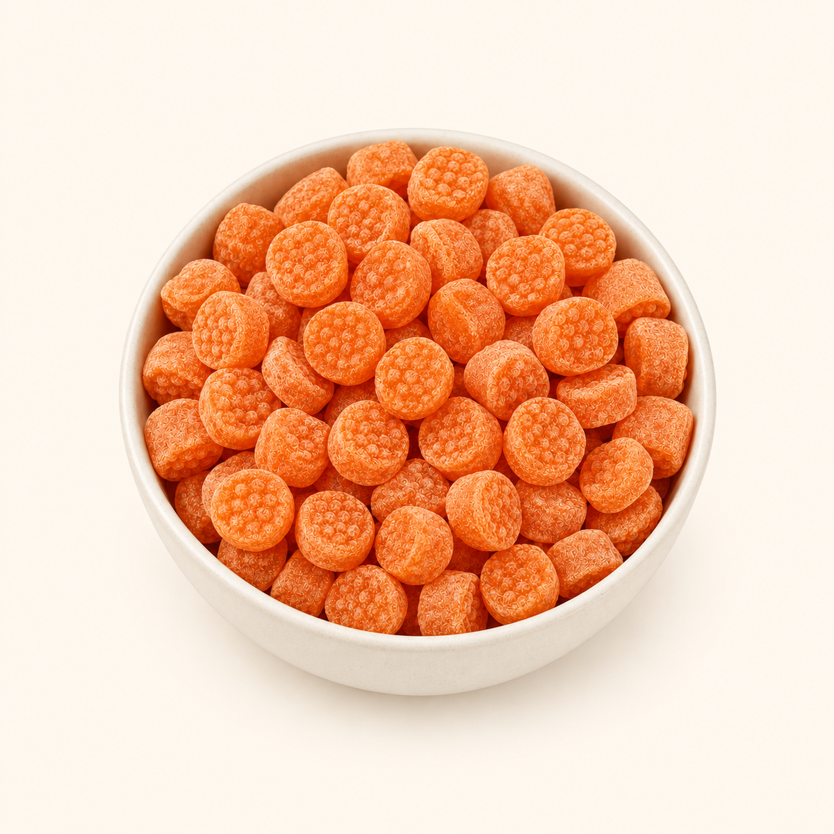 Orange Candy in a bowl on an off-white background